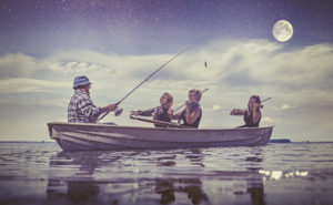 Vapaa-ajankalastaja kalastamassa viulustien soittaessa samassa veneessä.