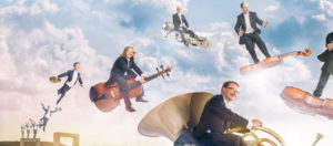 Kuvankäsittelyn keinoin laitettu Kuopion kaupunginorkesterin muusikkoja lentämään soittimillaan.