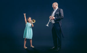 Tyttö ja muusikko trumpettien kanssa