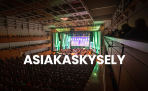 Orkesteri Konserttisalin lavalla ja teksti Asiakaskysely.